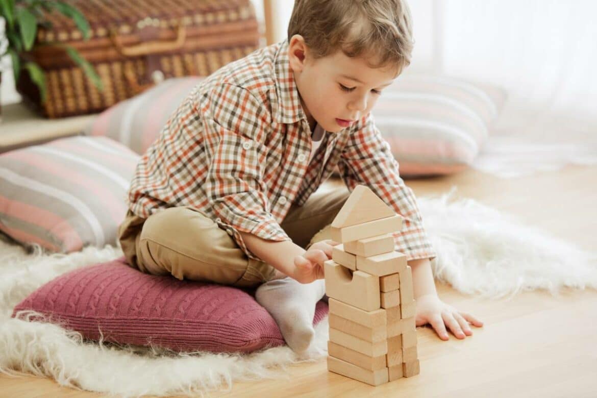 enfant qui joue avec des jouets en bois