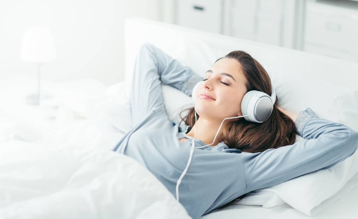 femme qui écoute une musique relaxante dans son lit